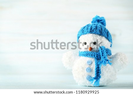 Small snowman toy on wooden table