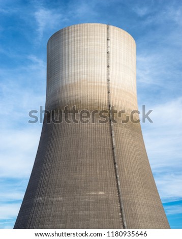 A huge chimney of a nuclear power plant close up on a background of blue sky with clouds, with clipping path.

