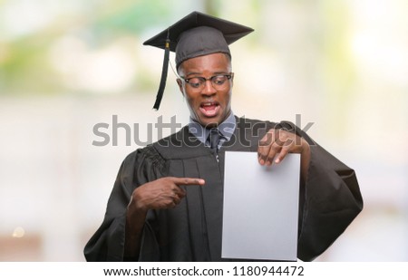 Young graduated african american man holding blank paper degree over isolated background very happy pointing with hand and finger