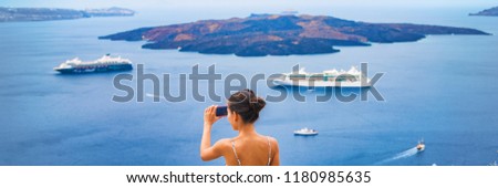 Europe Mediterranean vacation travel tourist taking holiday photo with phone of cruise ships in Aegean sea in Oia, Santorini, Greece. Europe vacation destination panoramic banner.