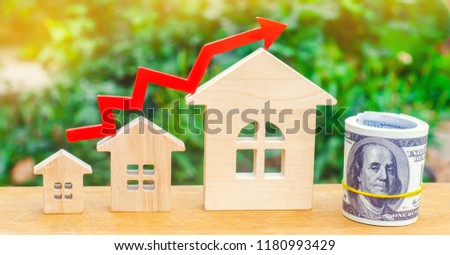 Wooden houses stand in a row from small to large with a red arrow up. concept of high demand for real estate. increase energy efficiency of housing. rise in house prices. property. population growth