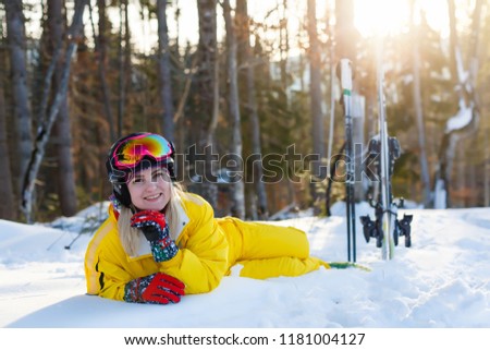Ski, snow and sun - resting female skier in winter resort