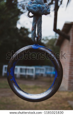 Close up photograph of an abstract, metallic blue circular ring hanging 
