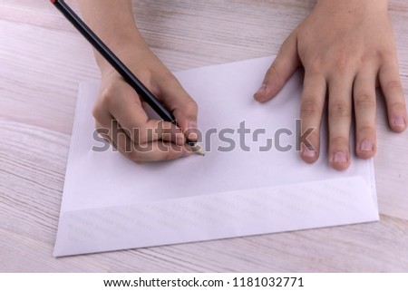 Christmas gifts: the child prepared envelopes for letters to Santa Claus, a wooden table