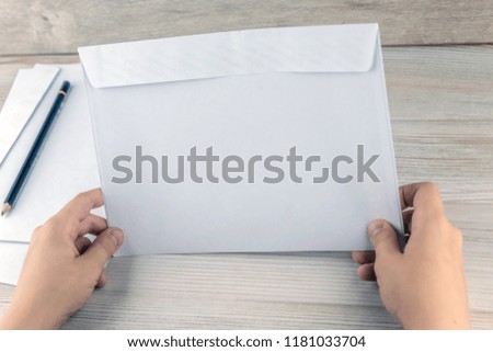 child prepared envelopes for letters to Santa Claus, a wooden table