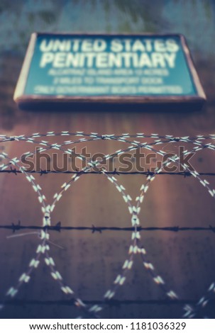 A Sign For A High Security United States Penitentiary Or Prison Behind Razor And Barbed Wire