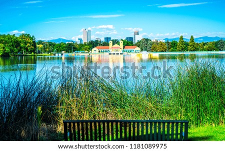 Open Park seat to enjoy Green summer morning at City Park in Denver , Colorado , USA with reflection pond and skyline cityscape in the far distance with Rocky Mountains in the background