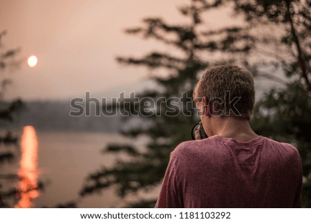 man taking photo of sunset