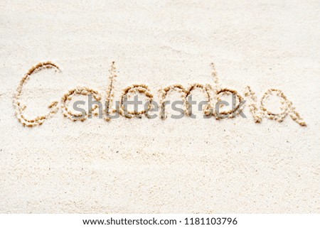 Handwriting words "Colombia" on sand of beach