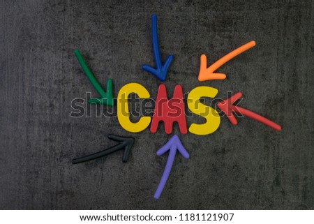 CMS, Content management system concept, multi color arrows pointing to the word CMS at the center of black cement chalkboard wall, the system to manage content of modern resposive website.
