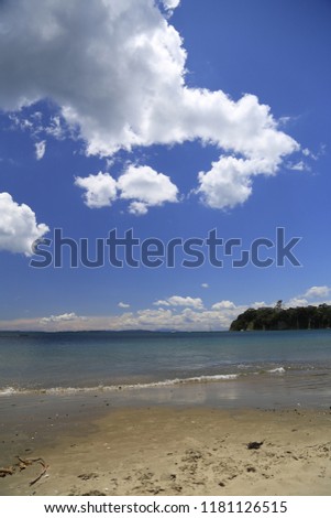 Beach view with land, sea, sand and sky.  Taken at stanmore bay in Auckland, New Zealand. Royalty-Free Stock Photo #1181126515