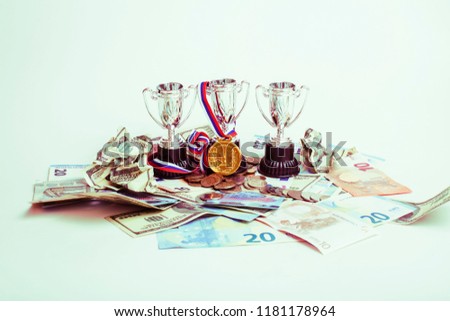 Sport winning concept: three cups among diverse currencies euro,