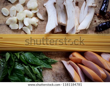 picture of the pasta ingredient consist of spaghetti, sausage, chili, mushroom, Thai basil and garlic. Selective focus