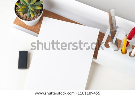 Top view white paper note on modern office stationery on white table.pencil, notepad,ruler,pen and pencil box with plant.Mock up paper note for display of design or content