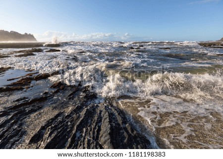 Rough surf and waves on a beach in New Zealand.
