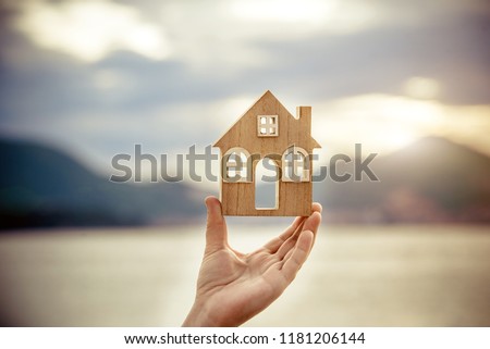 Girl holding the symbol of the house over the sea 