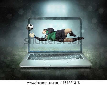 Caucassian soccer Player in dynamic action jump with ball in a professional sport game play on the laptop in football under stadium lights.