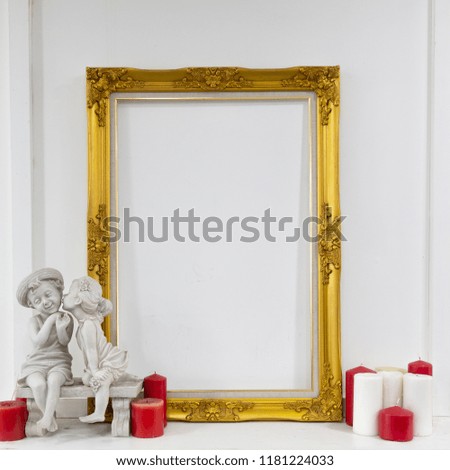 Golden picture frame with chidren statue and candles.