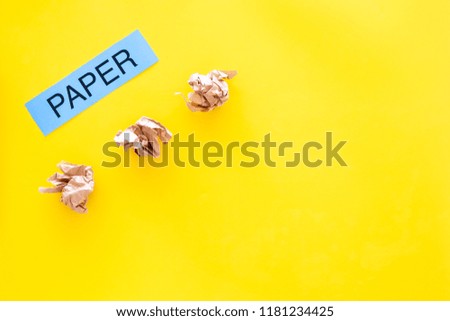Waste suitable for recycle. Crumpled paper near printed word paper on yellow background top view copy space