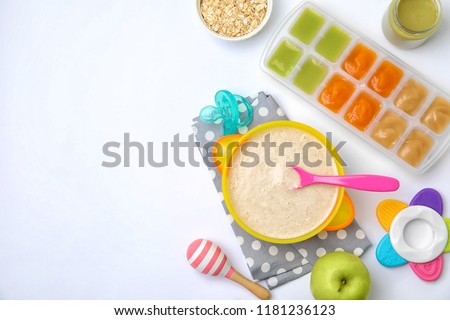 Flat lay composition with bowl of healthy baby food and space for text on white background Royalty-Free Stock Photo #1181236123