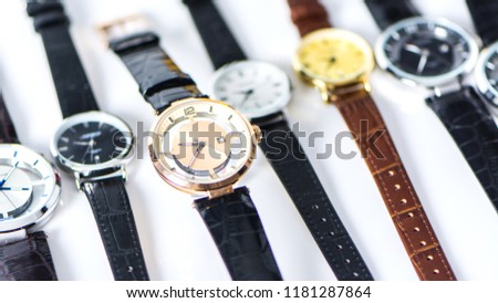 Close up of luxury fashion watch with gold dial and brown crocodile grain leather watch band,  Luxury Watches on white background. Formal collection of man wrist watch on shelves, silver, black, blue
