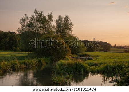 Beautiful landscape image of Burford village in English Cotswolds countryside during Summer evening