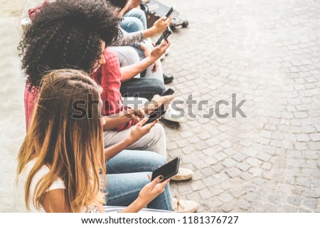 Happy millennials friends surfing online with mobile phones - Young people using smartphone outdoor - Youth lifestyle, generation z and technology trend concept - Focus on bottom hand cellphone Royalty-Free Stock Photo #1181376727