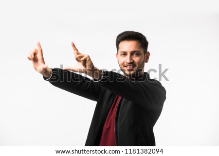 Indian/asian man making a frame using his hands and fingers, trying to find perfect good sight, isolated on white background