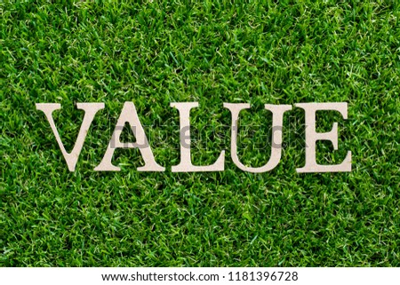 Wood letter in word value on artificial green grass background
