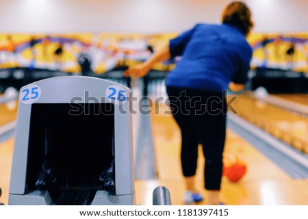 Back view of woman play bowling and throwing ball.focus on Bowling alley.Relaxing sport fun concept.