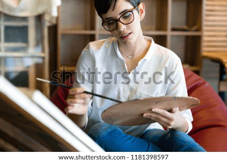 Creative pensive art school painter working on painting