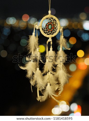 Dream catcher at night with a bokeh background of multi-colored lights, boho chic, ethnic emulet.
