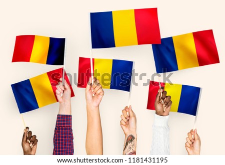 Hands waving flags of Romania
