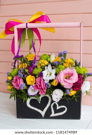 Picture of different flowers in wooden box painted with hearts by chalk
