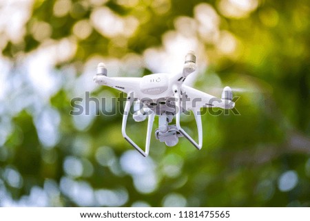 Drone is flying with digital camera to take photo and video on ground at sunset time.