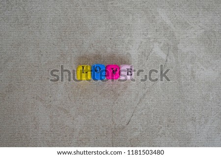 Love written with colorful cube letters on a colorless surface