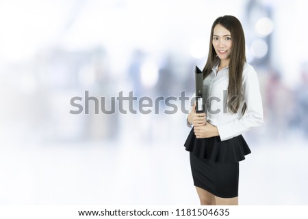 Young asian business woman holding file document in blurred background.