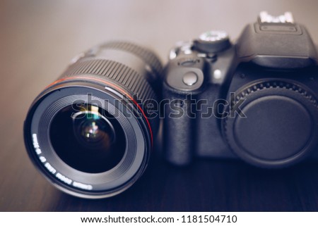 Digital camera or DSLR with camera lens with lense reflections. Photo Camera or Video lens close-up on black background DSLR objective