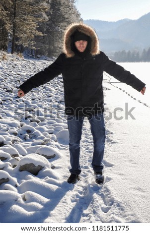 Man in warm jacket enjoying winter nature landscape in Altai Mountains, Siberia, Russia