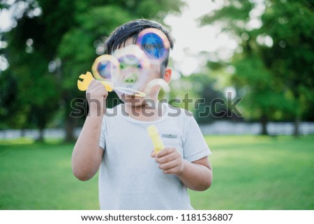 Little boy make a soap bubbles in park