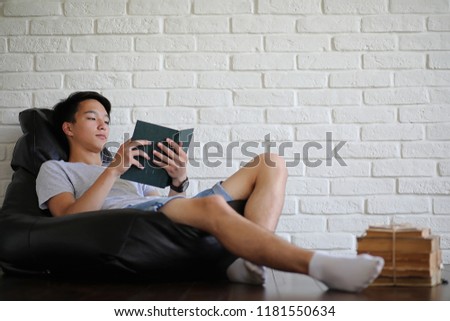 Young Asian student sitting on pillow and getting ready for exam
