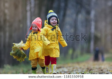 Little children are walking in the autumn park in the fall of leaves
