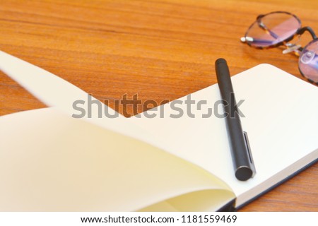 Skecthing book or notebook with fountain pen and glasses on my wooden table