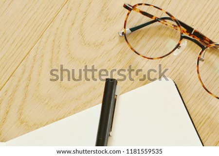 My sketching book, pen and glasses on wooden background in the office