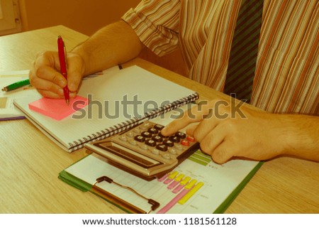accounting and business concept. The Man sits at the table with a calculator and business accessories