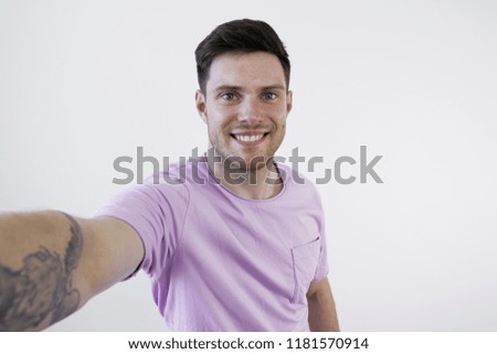 Young Smiling Man Taking Selfie on Phone. White background.Casual