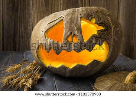 Jack o lanterns Halloween pumpkin face on wooden background.