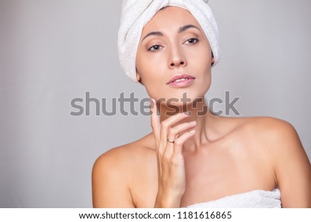 Woman young adult after the shower in a towel fresh uses the funds to care for the skin on an isolated background