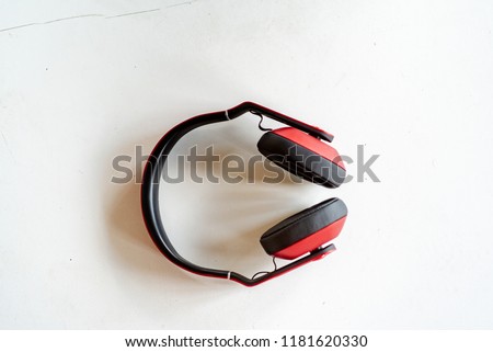 Red headphones on a white-grey background. Photo with small noise and soft similar focus.