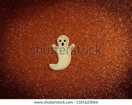 Halloween ghost on an orange glitter  background 